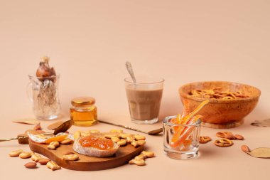 Bardakta kapuçino ile tatlı bir kahvaltı. Bej ve turuncu tek renk şeması. Kopyalama alanı olan yatay resim