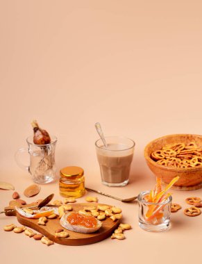 Bardakta kapuçino ile tatlı bir kahvaltı. Bej ve turuncu monokrom renk şeması fotokopi uzayı ile hala hayattadır. Portre yönelimi