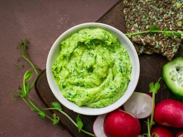 Green Pea Hummus Fresh Greens Vegetables Ckackers Served Wooden Board — стоковое фото