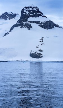 Snow Mountains Charlotte Bay Antarctic Peninsula Antarctica.  Glacier ice blue because air squeezed out of snow.