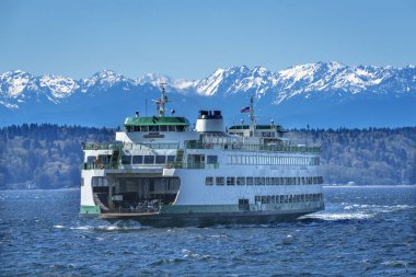 Washington State Ferry Olympic Snow Mountains Edmonds Washington.  Ferry arriving at Ferry Port on Puget Sound. clipart