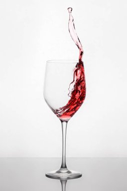 Sıçramasına ve kırmızı şarap kadehinin ayakta açık renkli yansıması ile karşı mahkemeye taşıma