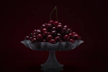 Taze tatlı kiraz bir fotoğraftaki cam vazo düşük anahtar