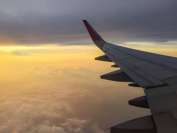 Bir bulutlu gün batımı renkli gökyüzü ile uçuş yolcu jet yolcu uçağı uçak kanadı yüksekte.