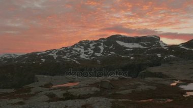 Dağların üzerinden günbatımı. Trolltunga alan, Norveç. Pürüzsüz dolly vurdu
