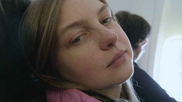 Молодая женщина хочет спать в самолете — стоковое видео