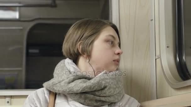 Уставшая молодая женщина пытается спать в метро — стоковое видео