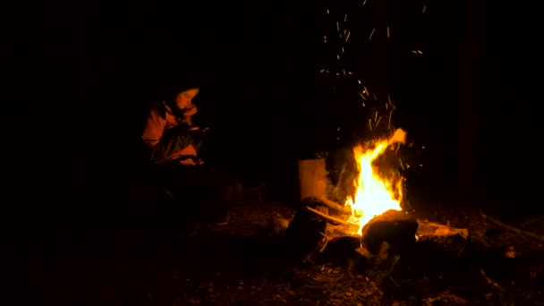 Fille avec des smartphones près du feu de joie dans la forêt la nuit — Video