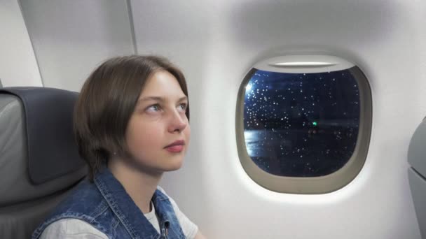 Jovem mulher olhando através da janela no avião — Vídeo de Stock
