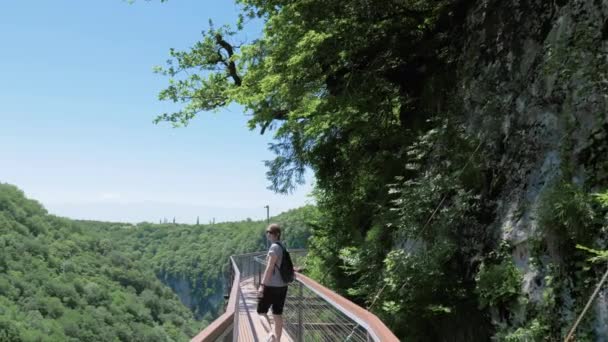 Una giovane donna cammina sul ponte di osservazione. Okatse Canyon, vicino Kutaisi, Georgia — Video Stock