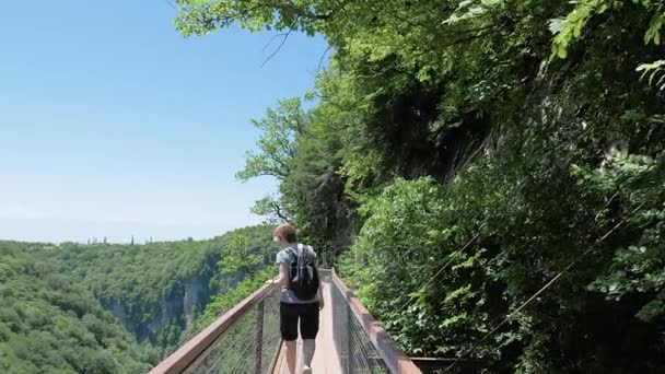 Mujer joven camina en la plataforma de observación. Okatse Canyon, cerca de Kutaisi, Georgia — Vídeo de stock