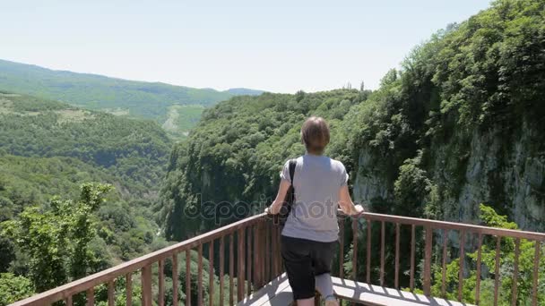 Mujer joven camina en la plataforma de observación. Okatse Canyon, cerca de Kutaisi, Georgia — Vídeo de stock