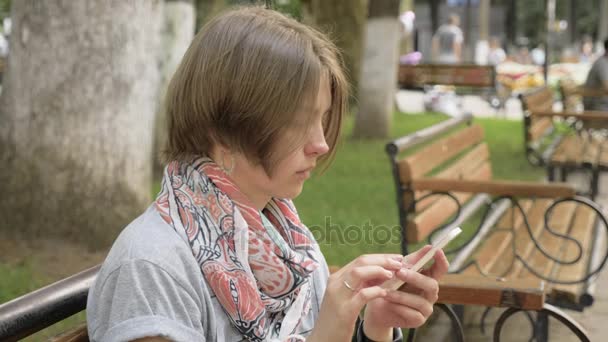 Mujer joven mira el teléfono en el parque de la ciudad, Georgia — Vídeo de stock