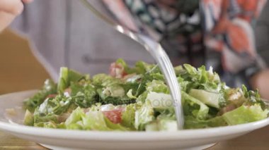 Genç kız salat yiyor.