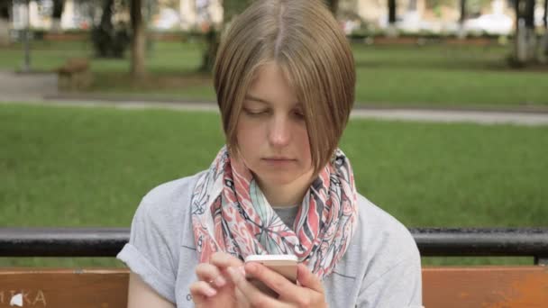 Mujer joven mira el teléfono en el parque de la ciudad, Georgia — Vídeos de Stock