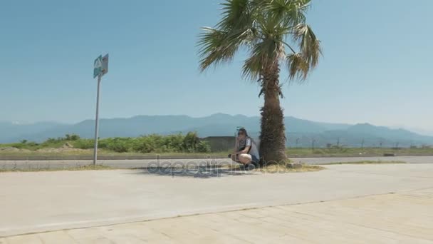 Una chica linda descansa cerca de la palmera. Batumi, Georgia — Vídeo de stock