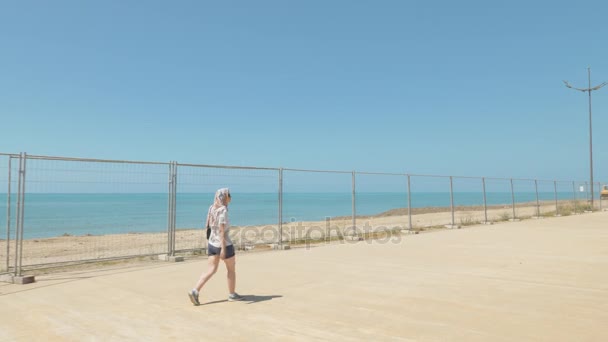 Chica joven camina a lo largo de la valla de metal. Batumi, Georgia — Vídeo de stock