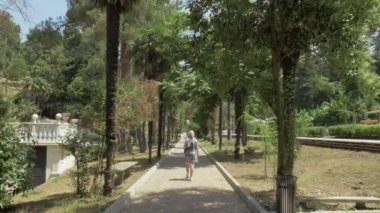 Genç kız palmiye sokak yürüyüş. Batum Botanik Bahçesi, Georgia