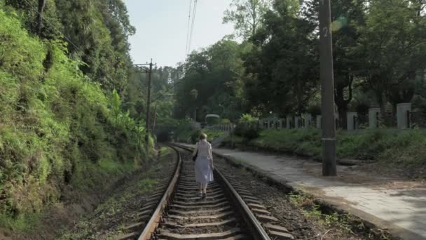 Молодая девушка ходит по железной дороге. Грузия — стоковое видео