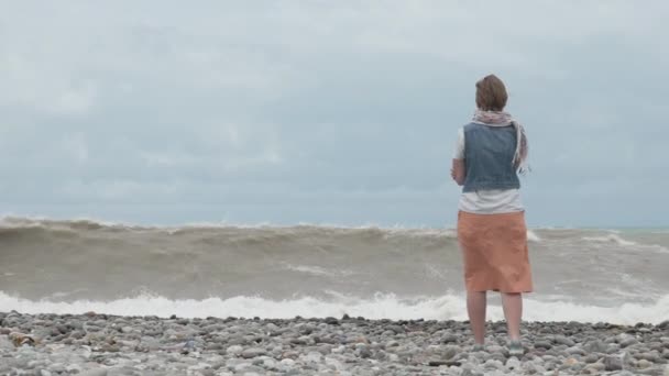 Fiatal lány a strandon pillantást magas hullámok az óceán - Georgia — Stock videók