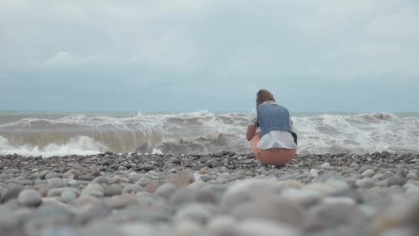 Jong meisje op het strand kijken naar hoge golven van de oceaan - Georgië — Stockvideo