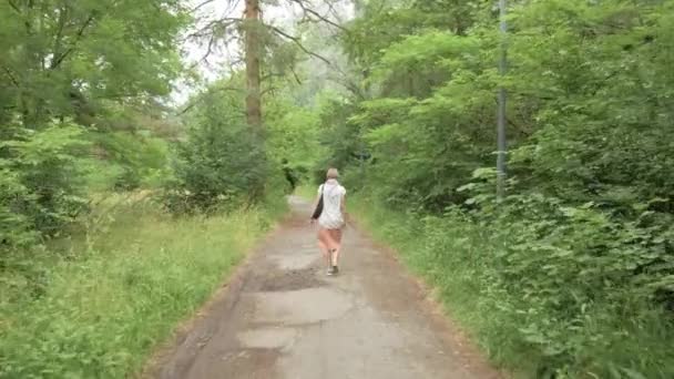 公園を歩いている若い女性は — ストック動画