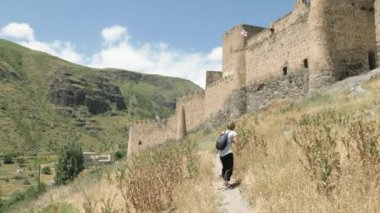 Genç kız yürüyüş ve görmek Khertvisi kale - Georgia