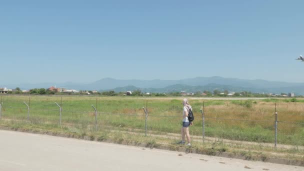 Young girl walks along the barbed fence of airport. Batumi, Georgia — Stock Video