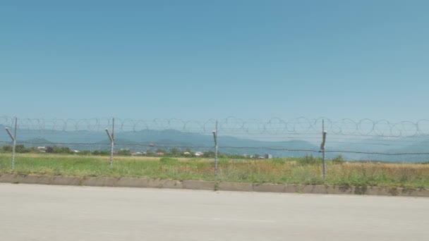 Περπατώντας κατά μήκος του φράχτη από αγκαθωτό σύρμα του αεροδρομίου. Μπατούμι, Geoargia — Αρχείο Βίντεο