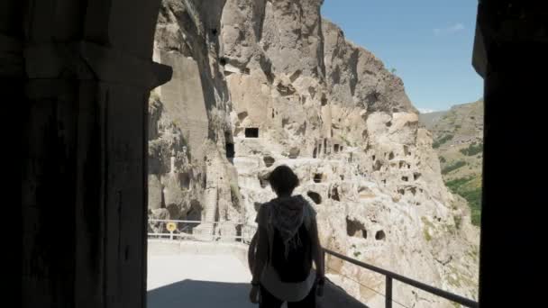 Chica joven camina en el monasterio cueva Vardzia - Georgia — Vídeos de Stock
