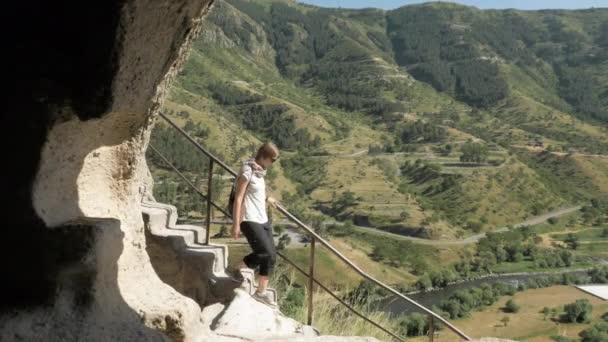 Jong meisje loopt de trap in de grot klooster Vardzia - Georgië — Stockvideo