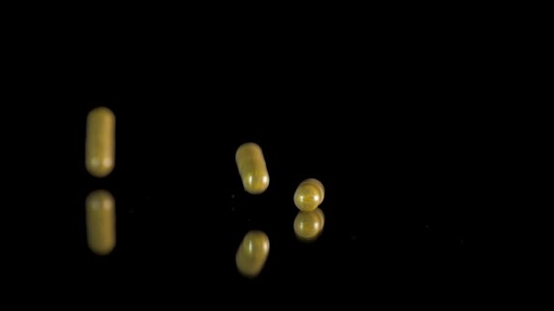 Pilule capsules tombant sur la table miroir. Coup de ralenti, 180 ips — Video