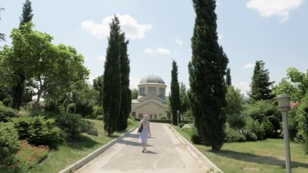 Junges Mädchen mit Blick auf die Dreifaltigkeitskathedrale von Tiflis tsminda sameba - Georgien — Stockvideo