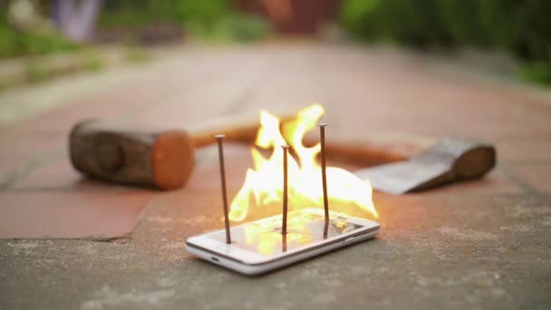 Brisé avec des ongles téléphone portable sur le sol est en feu au ralenti — Video