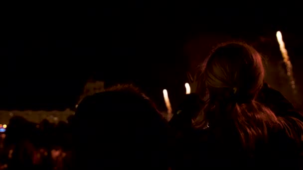 People look at the fireworks show on holiday in the evening at night — Stock Video