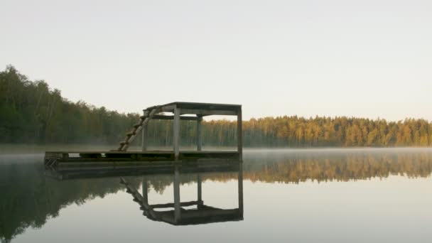 Dykning trä torn på sjön på morgonen dimma bredvid höstskogen — Stockvideo