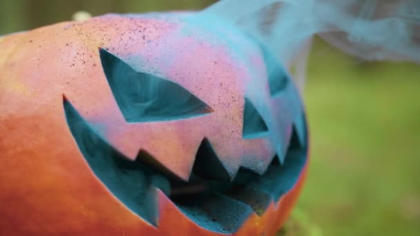 Halloween pompoen met gekleurde rook in het herfstbos — Stockvideo