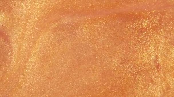 Barevný zlatý písek se organicky pohybuje v barevné tekutině v makru — Stock video