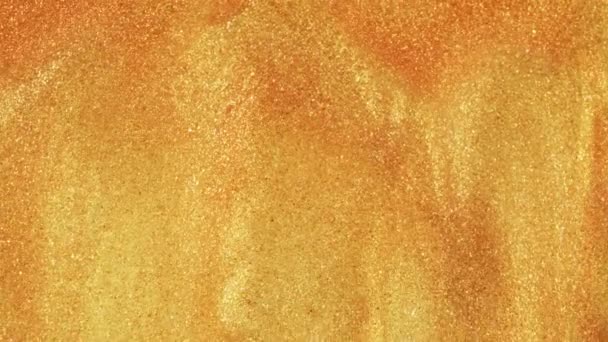 Sable doré coloré se déplace organiquement dans un liquide coloré en macro 