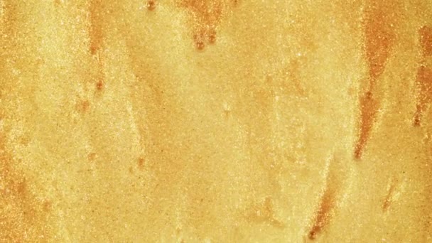 Bunter goldener Sand bewegt sich organisch in bunter Flüssigkeit im Makro — Stockvideo