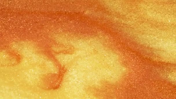 Sable doré coloré se déplace organiquement dans un liquide coloré en macro 