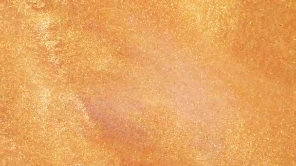 Sable doré coloré se déplace organiquement dans un liquide coloré en macro 