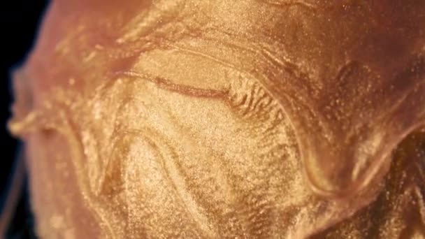 Zlaté částice inkoustu proudí ve vodě jako karamel na lízátku — Stock video
