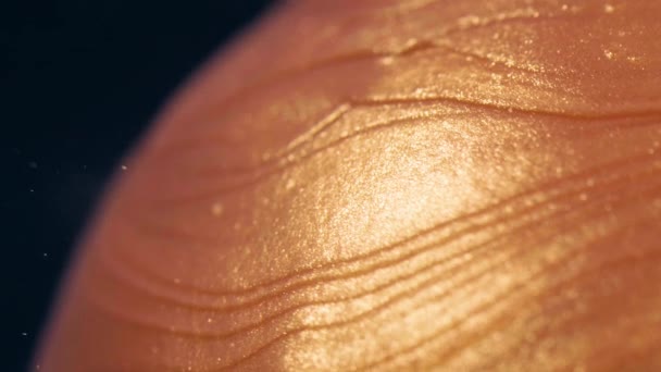 Goldfarbenpartikel fließen im Wasser als Karamell auf den Lutscher — Stockvideo