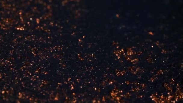 抽象的なカラフルな赤金色の砂は、有機的にマクロでカラフルな液体に流れ、黒の背景 — ストック動画