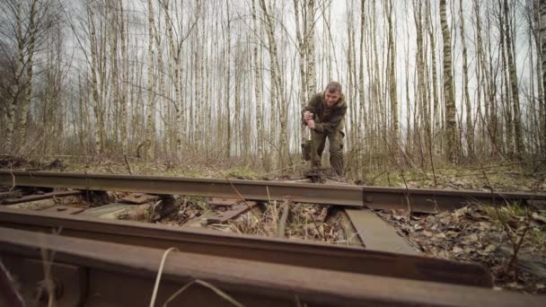 Καυκάσιος εργαζόμενος swithes μηχανισμό βέλη των τροχιών στη σιδηροδρομική γραμμή το φθινόπωρο του δάσους — Αρχείο Βίντεο