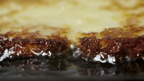 Los panqueques de papa draniki se fríen en aceite vegetal en una sartén, macro shot — Vídeos de Stock