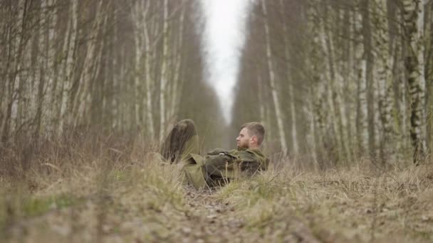 Кавказька людина лежить у лісі на залізничних рейках восени. — стокове відео