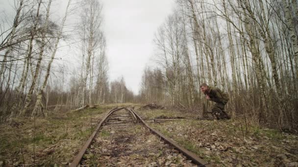 Trabajador caucásico swithes flechas mecanismo de vías en el ferrocarril en otoño bosque — Vídeo de stock