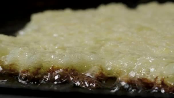 Картофельные блинчики драники жарят в растительном масле на сковороде, макро-шот — стоковое видео